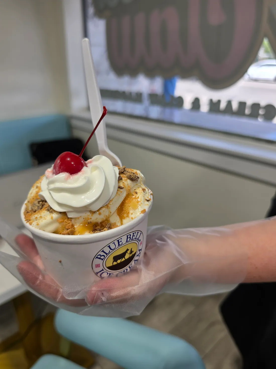 A sundae being handed over the ice cream counter